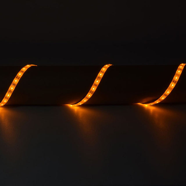 LYYT 12V Amber LED Strip Light draped in three curves over a cylindrical surface, glowing warm amber along the flexible IP65 tape against a dark background.