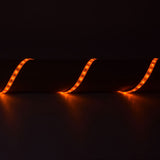 LYYT 12V amber LED strip light by AVSL, IP65 flexible 5m tape with 60 LEDs per metre, shown lit in a curving run casting a warm amber glow on a dark surface.