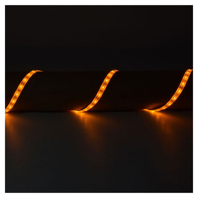 A dark room with LYYT 12V LED Strip Light 5m - Amber, featuring IP65-rated LED strips arranged in a wavy pattern, glowing in orange against a black background, emphasizing their low power consumption.