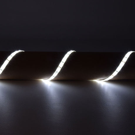 LYYT 12V SMD2835 LED strip light draped in curves over a surface, emitting bright 6000K cool white illumination against a dark background.