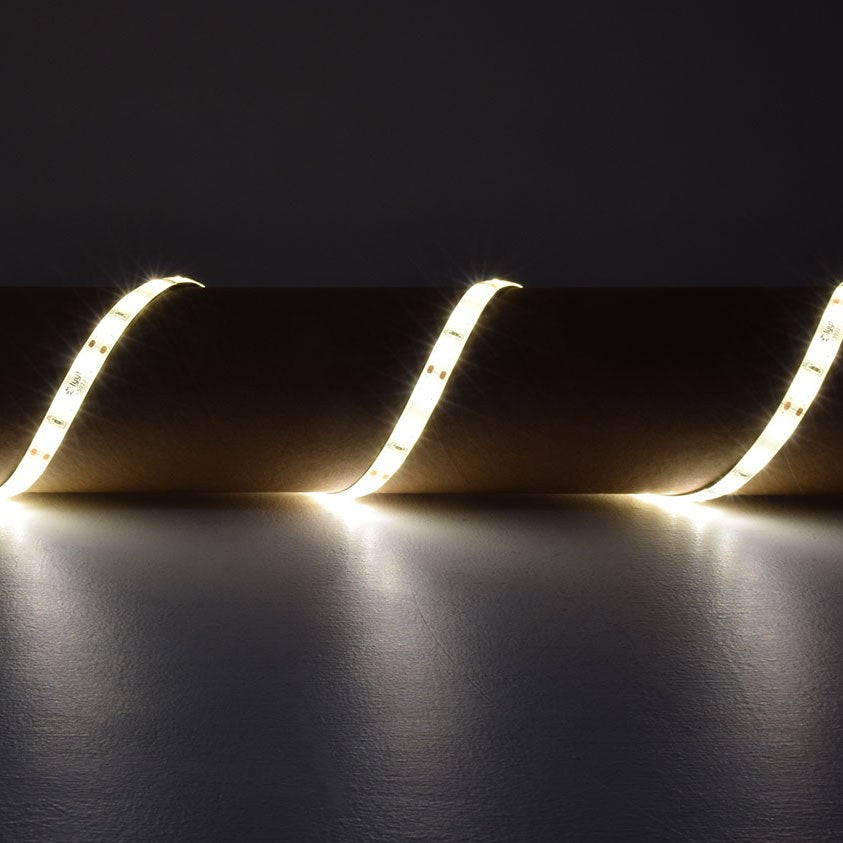LYYT 5m warm white LED strip light by AVSL, draped in curved loops emitting 3000K glow against a dark grey backdrop.