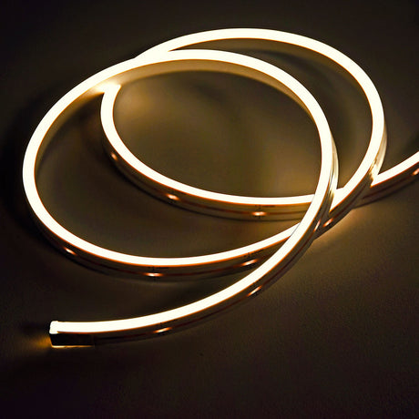 Coiled LYYT SideBend WW 30m warm white LED tape by AVSL, illuminated in a soft 2700K glow with visible DC24V markings along the frosted flexible strip.