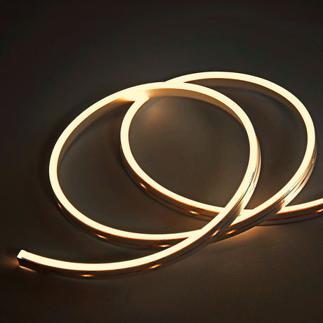 LYYT SideBend WW 30m warm white LED tape by AVSL coiled in loops, glowing evenly along its frosted side-bending strip on a dark background.