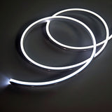 LYYT SideBend CW 30m LED tape coiled in loops, illuminated cool white 5000K with a smooth frosted line of light on a dark surface.
