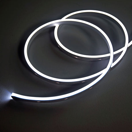 LYYT SideBend CW 30m LED tape coiled in loops, illuminated cool white 5000K with a smooth frosted line of light on a dark surface.