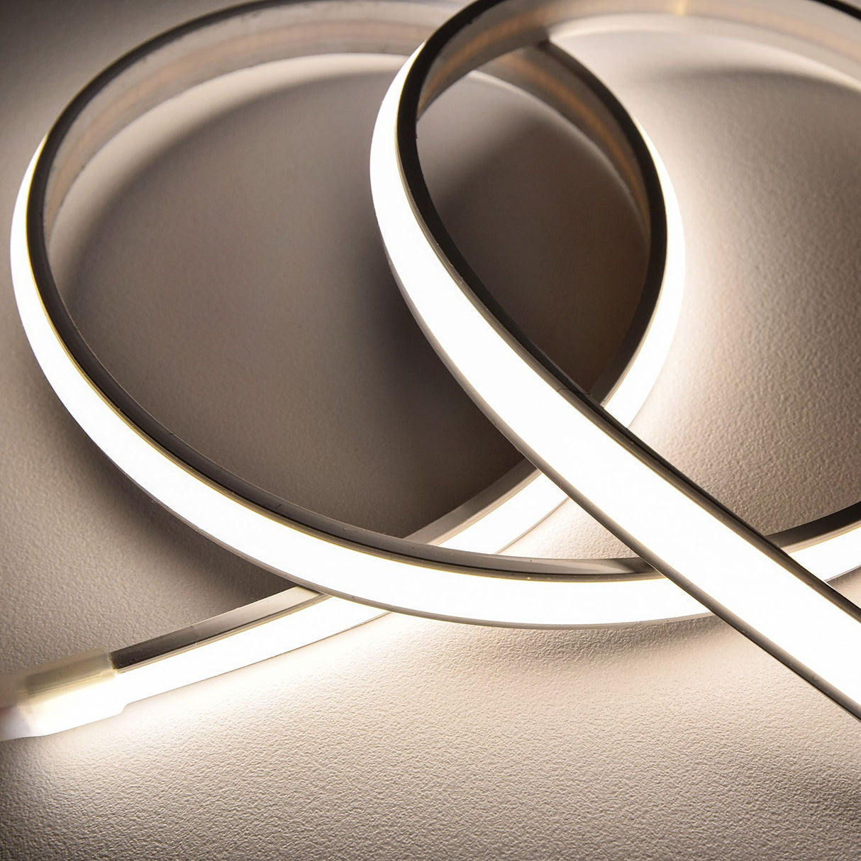 LYYT Frosted NW COB 24V IP66 Dome LED Tape by AVSL, shown looped and illuminated in natural white, highlighting the slim domed silicone extrusion.