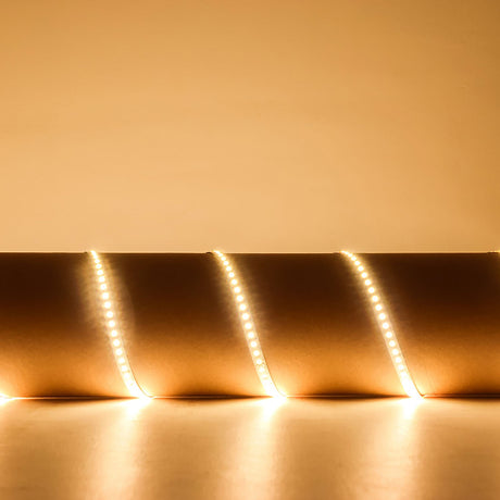LYYT 24V High Output LED strip light coiled and illuminated in warm white 3000K against a softly lit neutral background.