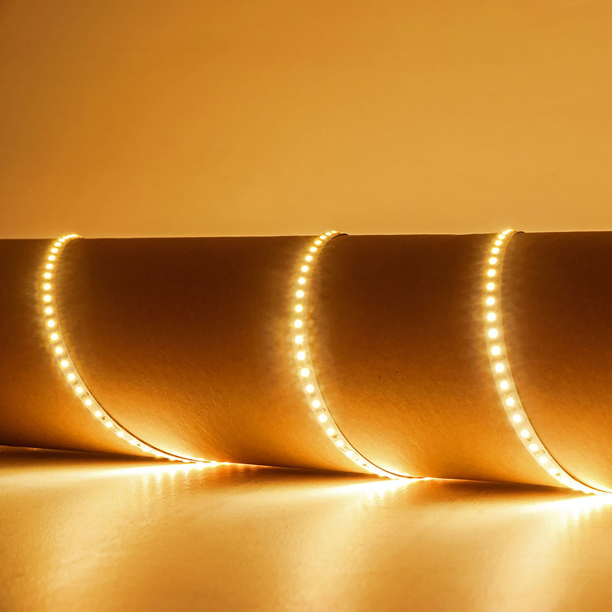 LYYT 24V LED strip light by AVSL curled in loops, emitting warm white 3000K glow across a neutral surface.