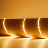 LYYT 24V LED strip light by AVSL curled in loops, emitting warm white 3000K glow across a neutral surface.