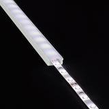 LYYT Short Crown 2m surface mount LED profile with lit LED strip partially inserted into the frosted aluminium extrusion, shown on black.