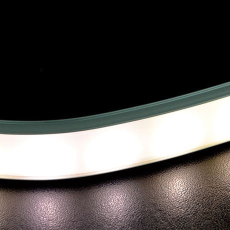 Close-up of the AVSL LYYT bendable surface mount LED strip profile, a curved 1m aluminium channel with opaque white diffuser on a dark textured surface.