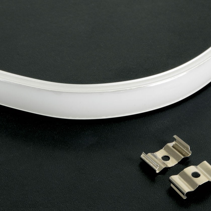 LYYT bendable surface mount LED strip profile in white curved aluminium with polycarbonate diffuser, shown with two silver metal mounting clips on black.