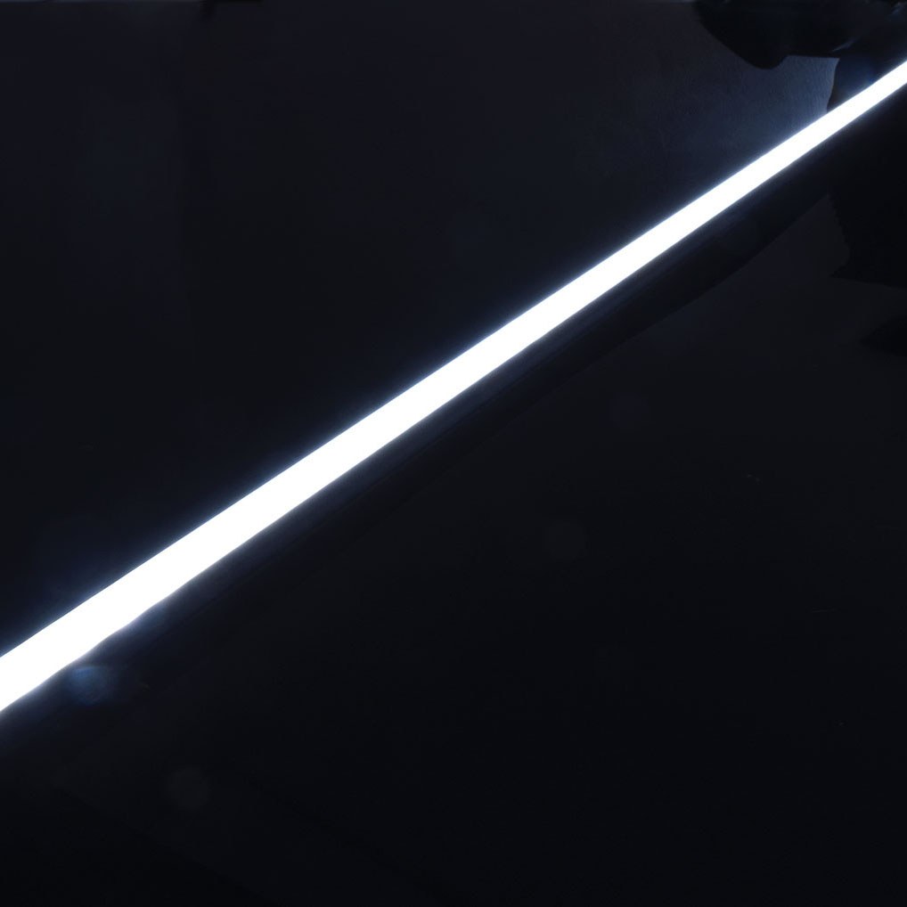 LYYT Tall Crown 2m surface mount LED profile by AVSL, illuminated diagonally with a bright crowned diffuser glowing against a black aluminium body.