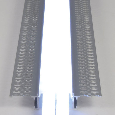 Close-up of LYYT by AVSL aluminium wide flush plaster-in LED tape profile, showing perforated side flanges and central illuminated white diffuser channel.