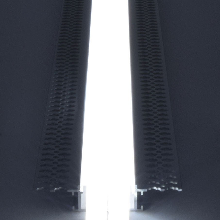 Close-up of the LYYT Aluminium LED Tape Profile Wide Plaster-in 2m by AVSL, showing the illuminated white diffuser between two perforated aluminium edges.