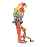 Macaw on Branch Metal Trinket Box with Hinged Lid in red, enamelled in red, yellow, green and blue with gold-tone feather detail and blue jewel accents, on a plain white background.