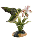 Hummingbird and Lily Metal Trinket Box with Base in glossy green, featuring a crystal-accented bird with raised wings sipping a pink-and-white lily on a rocky base, shown on a white background.