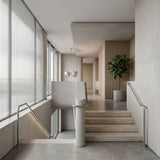 A modern minimalist interior features concrete stairs, metal railings, a potted plant, wood paneling, large windows with sheer blinds, and two Cereza LED 2 Light Pendants in silver hanging from the ceiling.