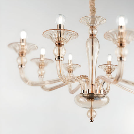 A close-up of the Breeze Glass 6 Light Chandelier - Gold, featuring six glass arms with glowing bulbs. This elegant chandelier showcases translucent, curved glass shades and metallic accents in a luxurious gold finish, set against a plain white background.
