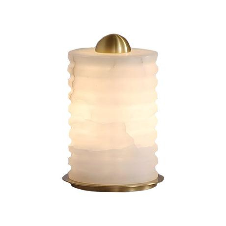 The Aurelior LED Small Ribbed Alabaster Table Lamp – Soft White features a modern cylindrical frosted glass shade with wavy ridges, gold accents, and emits warm light—perfect for cozy bedside spaces.