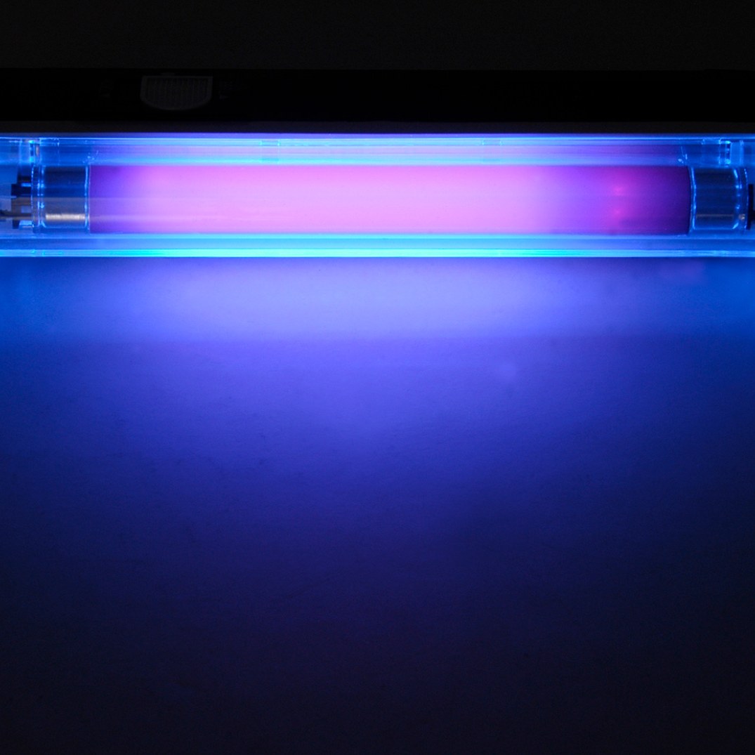 QTX BL135 Mini Black Light UV Torch Lamp by AVSL switched on, showing the illuminated 135mm purple UV tube glowing within a clear casing on matt black.