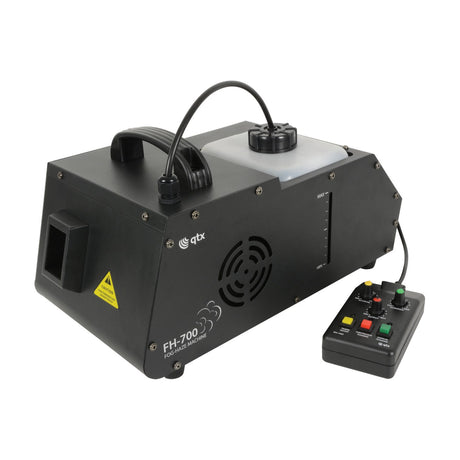 QTX FH-700 700W fog and haze machine in black metal housing with translucent fluid tank, side vent, and wired timer remote with control knobs.