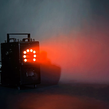 QTX QTFX-LBF2 800W LED bubble and fog machine by AVSL, steel body with front RGB LED panel glowing red through haze on a dark background.