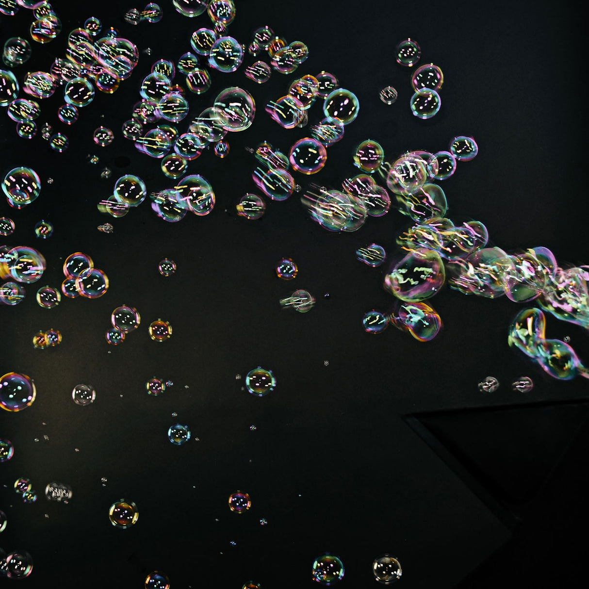Iridescent bubbles filling a dark stage space, produced by the QTX QTFX-B4 dual wheel bubble machine with four fans.