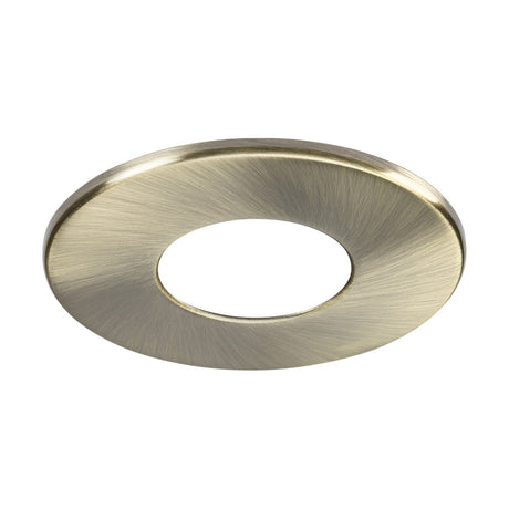 The Fixed Bezel for SpektroLED Evo features a circular metal design with an antique brass finish, complete with a central hole, seamlessly enhancing the refined look of fire-rated downlight surrounds.