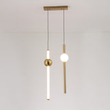 Two modern minimalist pendant lights with gold accents hang from the ceiling: one is the Sottile LED Vertical Suspension Light - Gold, featuring a frosted tube and gold sphere; the other has a vertical gold rod with a round white bulb.