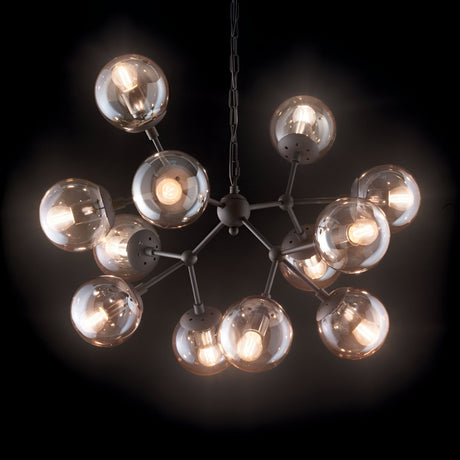 The Novara 12 Light Chandelier - Brown showcases a contemporary style with twelve luminous spherical bulbs and amber glass diffusers, arranged in a radial layout and suspended by a chain against a dark backdrop.