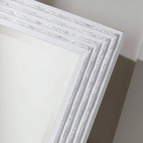 A close-up view of the Pearl Rectangle Wall Mirror - White/Silver showcases its decorative, silver-trimmed corner, embodying modern elegance against a light gray background.