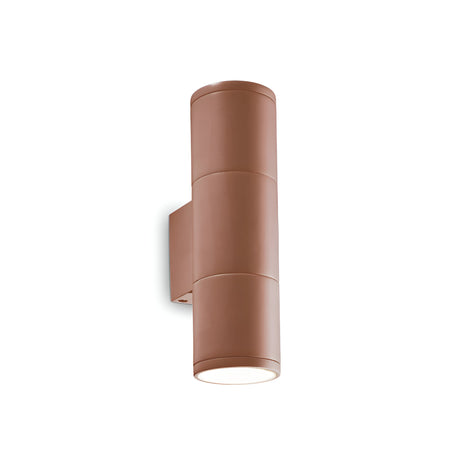 The Solar 2 Light Outdoor Small Wall Light in brown is a contemporary cylindrical wall sconce featuring a sleek design. It includes two light sources positioned on opposite ends and is mounted on a minimalist rectangular wall bracket. Resembling rustic outdoor lighting, it projects light both upwards and downwards against a white background.