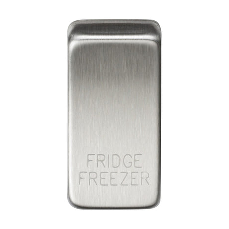 A brushed chrome switch cover featuring engraved text that reads "FRIDGE/FREEZER" on its polished surface.