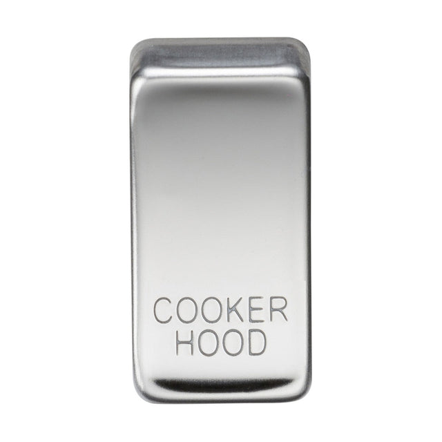 A rectangular switch cover labeled "COOKER HOOD," crafted from polished chrome, is designed to control a kitchen exhaust fan. Its smooth, reflective surface adds an elegant touch.