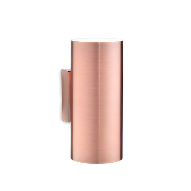 The Noctis 2 Light Wall Light in copper, featuring a modern cylindrical design with a smooth, brushed finish, is mounted against a white background. This elegant wall sconce has an adjustable light source and boasts a minimalist style, making it an ideal choice for accent lighting in contemporary interiors.