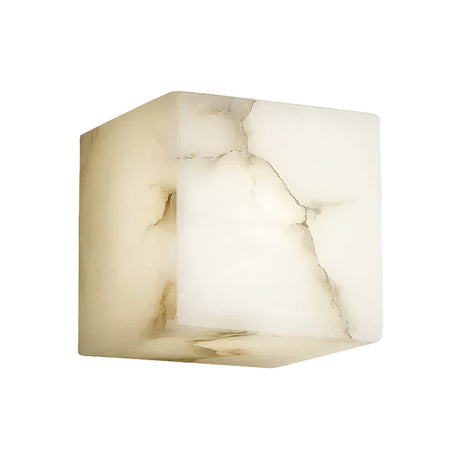 The Calmora 1 Light Block Alabaster Wall Light - Soft White is a cube-shaped fixture crafted from natural Spanish alabaster, showcasing translucent surfaces with gentle brownish veins and cracks against a white background.
