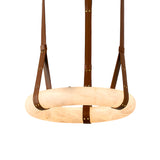 The Cintura LED Large Alabaster Suspension Light in soft white and brown features a circular Spanish alabaster ring, elegantly suspended by four brown leather straps with brass hardware.