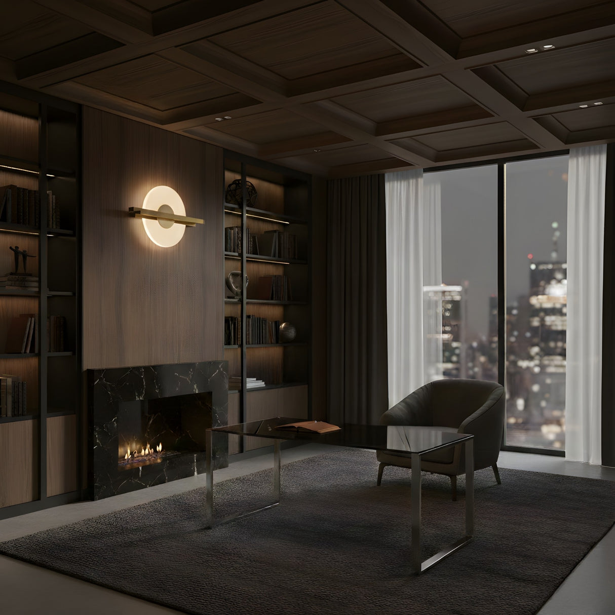 A modern office with dark wood bookshelves, black marble fireplace, glass desk, and gray armchair. Large windows reveal a city skyline at night. The Elyra LED Alabaster Wall Light in brushed brass adds warmth and sophistication.