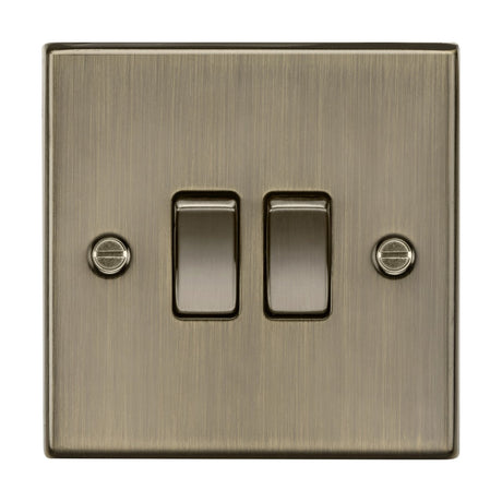 The 10AX 2 Gang 2-Way Plate Switch in antique brass features a vintage-inspired design with a brushed finish. Each square-edged switch includes side screws for wall securing, and both switches are positioned to be off.