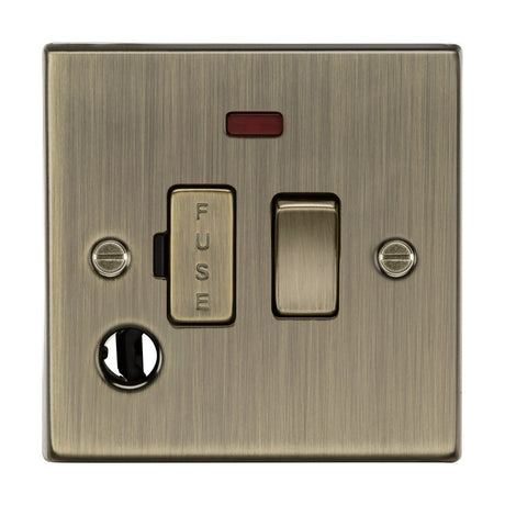 The 13A Switched Fused Spur Unit Neon & Flex Outlet in antique brass boasts a fused switch labeled FUSE, a power switch, red indicator light, and round plug socket. It features two visible screws securing the classic square-edge design.