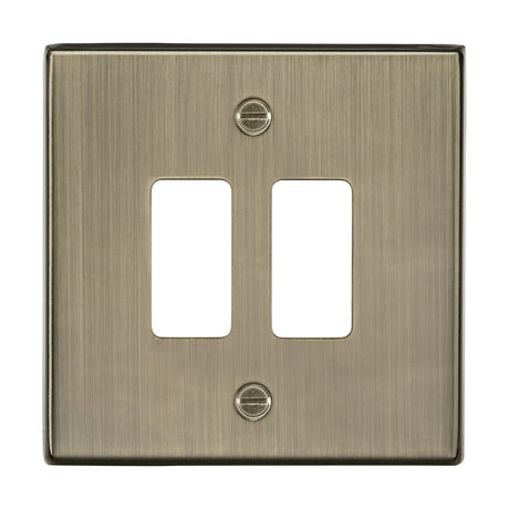 The 2 Gang Grid Faceplate - Antique Brass is a brushed metal double light switch plate with a sleek, modern appearance. It features a square-edge grid faceplate designed for two toggle switches and is part of the Knightsbridge Grid System, combining simplicity and functionality with an antique brass finish.