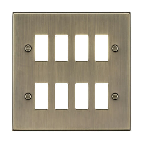 An 8 Gang Grid Faceplate, finished in brushed Antique Brass and designed for eight rectangular switches. This product is part of the Knightsbridge Grid System and is secured with four visible screws.