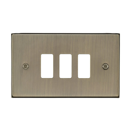 The 3 Gang Grid Faceplate in Antique Brass showcases three rectangular openings without switches and is designed with a smooth, metallic finish. It is secured by two visible screws and perfectly complements the Knightsbridge Grid System, adding a touch of elegance to any refined decor.