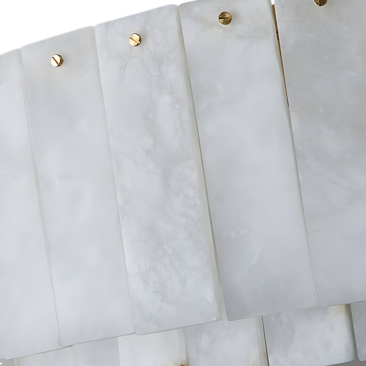 Close-up of overlapping rectangular alabaster tiles, each secured by a gold screw, forming the elegant, textured surface featured in the Arvello 12 Light Layered Panel Alabaster Chandelier in Soft White & Brass.