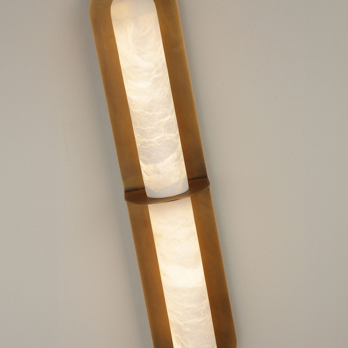 Niori Eliora LED wall light with illuminated Spanish alabaster column divided by a central horizontal bar within a brushed brass surround.