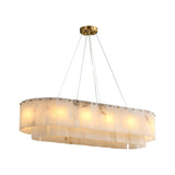 The Arvello 12 Light Layered Panel Alabaster Linear Chandelier features two tiers of soft white alabaster panels, a brass ceiling mount, internal lights, and is suspended by four thin wires.