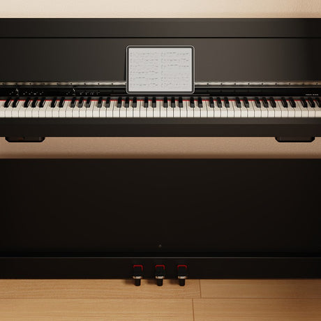 NU-X NCK-330 88-note weighted digital upright piano in black with sheet music on the stand, three pedals and full keybed, shown against a wood floor.