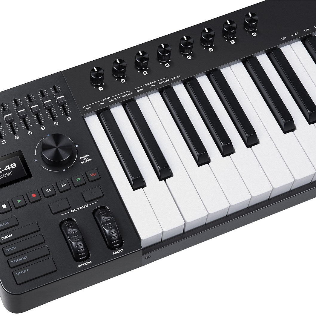 Close-up of the NU-X NTK-49 semi-weighted MIDI keyboard controller by AVSL, showing rotary knobs, sliders, display, transport keys, pitch and mod wheels.