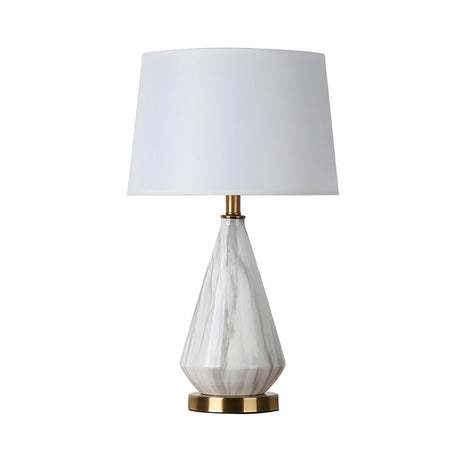 The Calvero 1 Light Diamond Facet Marble Table Lamp features a diamond-inspired white marble base, brass accents, and a large white lampshade, shown against a white background.
